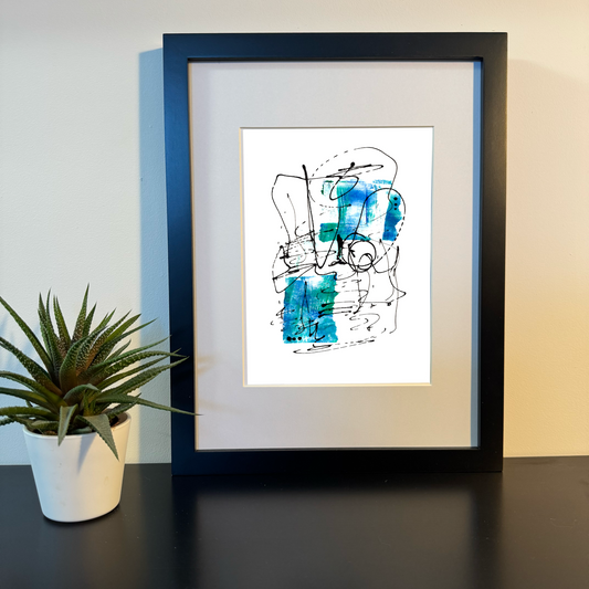 Artwork titled 'Fluid Harmony' in a black frame on a shelf next to a cactus plant.