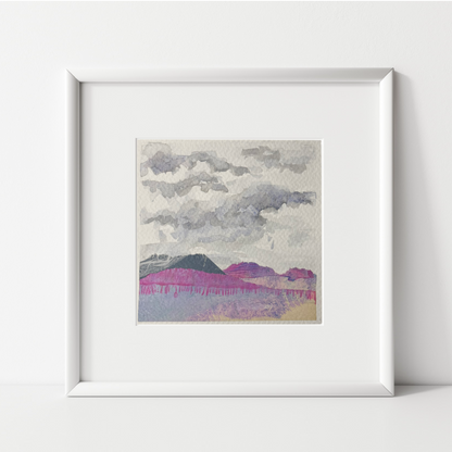 Mixed media landscape by artist Julia Hargreaves in a white frame on a shelf leant against a wall.