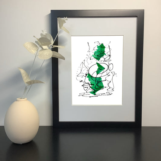 Image featuring a framed artwork on a shelf with a  ceramic vase and foliage.  The artwork by Julia Hargreaves features an expressive abstract design with green and black tones.