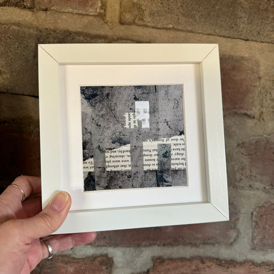 Image featuring a framed artwork being placed against a red brick wall.