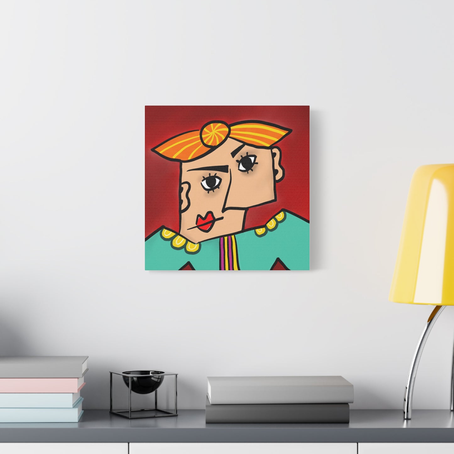 Colorful abstract painting of a face on a white wall above a shelf with books and a lamp.