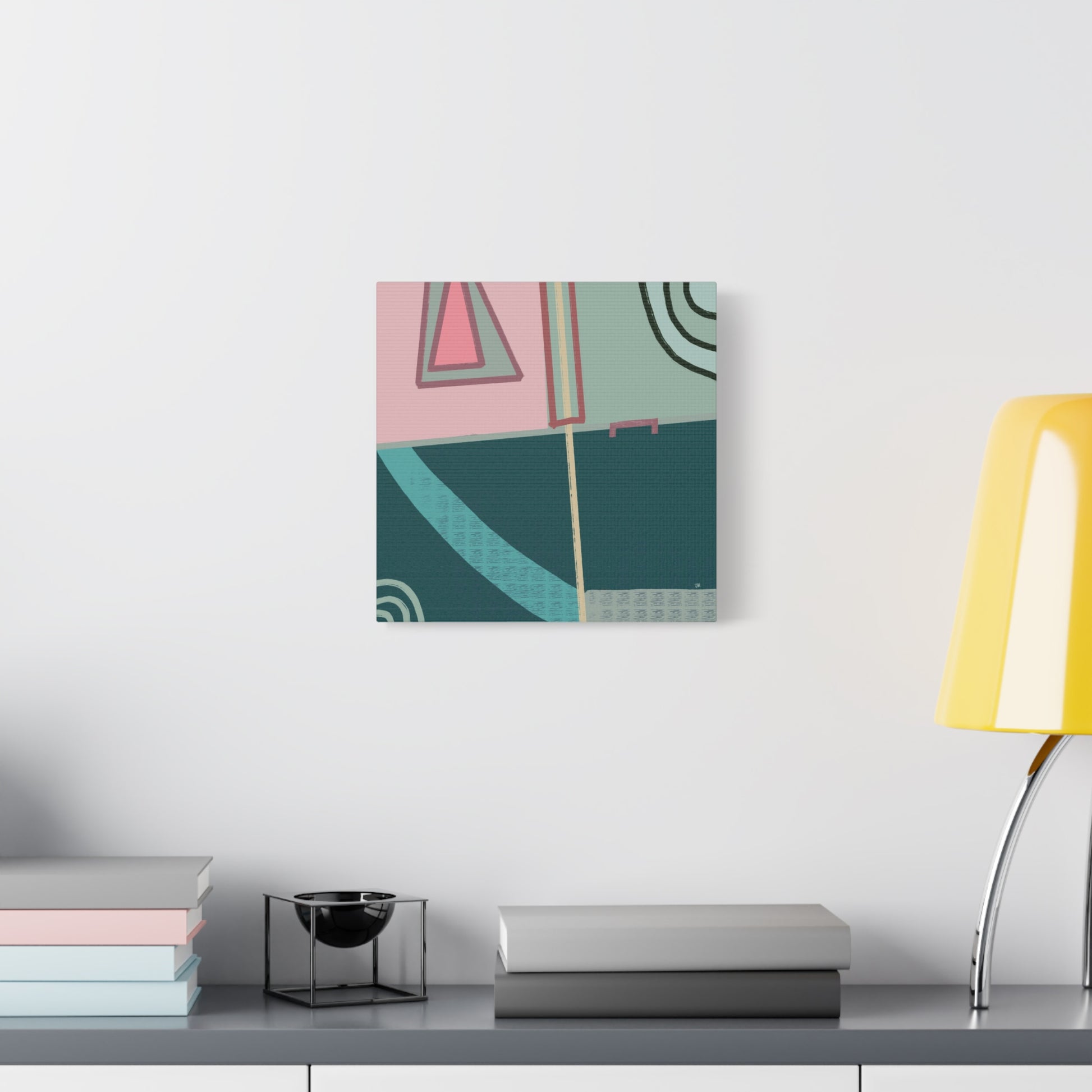 Intersecting Echoes abstract canvas print on a wall above a desk with books and a lamp.