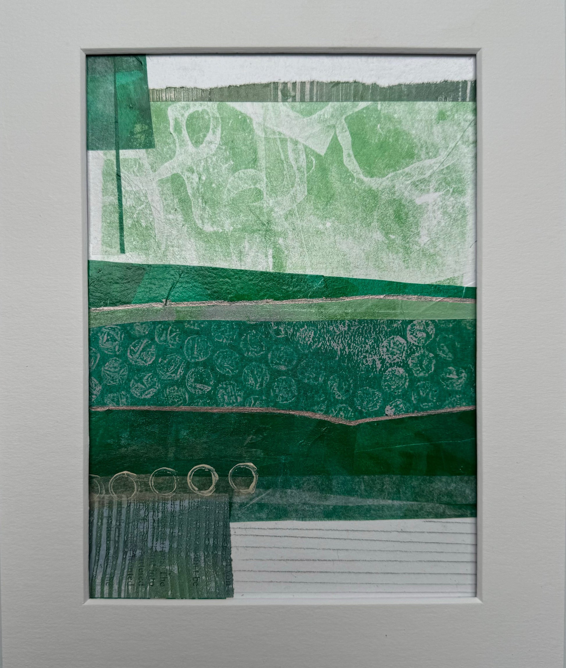 'New Horizons' by Julia Hargreaves abstract artwork with various shades of green and intricate patterns.  The top section features a light green background with white abstract shapes.  Below this there is a band of darker green and circular patterns followed by another section with even darker green and embossed circular designs that resemble bubbles.  The bottom part shows horizontal lines, giving the impression of text lines. 