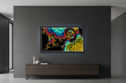 Sorrow and Pride — A colourful abstract fractal artwork with spiral and layered organic patterns in bright cyan, yellow, red, purple, and green on a black field-shown in a digital frame in a contemporary setting.